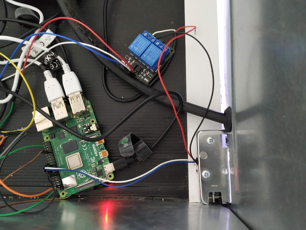 Raspberry Pi and relays wired inside a fridge cabinet